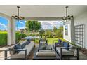 Covered patio featuring stylish outdoor seating, elegant lighting, and a view of the well-maintained backyard at 11878 N Hershey St, Surprise, AZ 85388