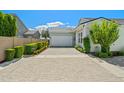 A beautiful one-story home featuring a stone driveway, lovely landscaping, and a welcoming two-car garage at 11878 N Hershey St, Surprise, AZ 85388