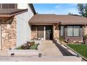 Close-up of the front of the home, showcasing a landscaped entrance, stone facade, and a welcoming front door at 12001 N 53Rd Ave, Glendale, AZ 85304
