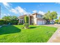 Charming two-story home with a well-manicured lawn, and an attached three car garage at 1401 E Brentrup Dr, Tempe, AZ 85283