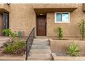 Exterior close up of front door with iron security door, desert landscaping and stairs at 1545 E Sahuaro Dr # 12, Phoenix, AZ 85020