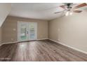 Open living room with wood-look flooring, neutral walls, ceiling fan, and french doors to outdoor space at 1545 E Sahuaro Dr # 12, Phoenix, AZ 85020