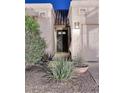 Close-up of the front entryway with well-maintained landscaping and a secure front door with multiple glass panes at 16857 E Deuce Ct, Fountain Hills, AZ 85268