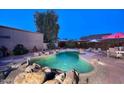 Backyard pool with rock waterfall feature and surrounding desert landscaping for a private oasis at 16857 E Deuce Ct, Fountain Hills, AZ 85268