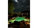 Inviting pool at night with underwater lights and decorative rocks create a relaxing backyard oasis at 16857 E Deuce Ct, Fountain Hills, AZ 85268
