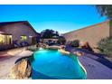 A refreshing backyard pool with a rock waterfall, lush landscaping, and inviting lounge areas at 16857 E Deuce Ct, Fountain Hills, AZ 85268