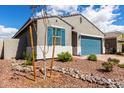 Beautiful home featuring desert landscaping, blue shutters, and a well-maintained exterior at 17454 W Red Fox Rd, Surprise, AZ 85387