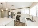 Modern kitchen featuring stainless steel appliances, white cabinets, quartz countertops, and pendant lighting at 4207 W Poinsettia Dr, Phoenix, AZ 85029