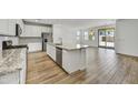 Open-concept kitchen with stainless steel appliances, an island and hardwood style tile floors at 5875 N 193Rd Dr, Litchfield Park, AZ 85340