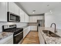 Modern kitchen featuring stainless steel appliances, white cabinets, and granite countertops at 5875 N 193Rd Dr, Litchfield Park, AZ 85340