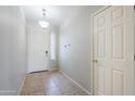 Welcoming entryway features neutral tile flooring, a hanging light fixture, and closet for storing coats at 6615 S 25Th Dr, Phoenix, AZ 85041