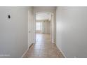 Bright hallway with tile floors that offers a view of the open-concept living area with lots of natural light at 6615 S 25Th Dr, Phoenix, AZ 85041