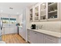 Stylish kitchen featuring custom white cabinetry with glass fronts and modern countertops at 7732 E Coolidge St, Scottsdale, AZ 85251