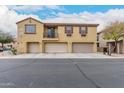 Two-story townhome featuring three garage spaces with neutral paint and desert landscaping at 8105 W Groom Creek Rd, Phoenix, AZ 85043