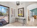 Inviting foyer with tile flooring, decorative mirror, and a view into the kitchen at 15546 W Whitton Ave, Goodyear, AZ 85395