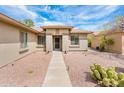 Charming home with a desert landscape leading to a secure front entrance at 16406 W Peppertree Ct, Surprise, AZ 85387