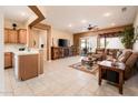 Spacious living room features tile flooring, a ceiling fan, and easy access to outdoor patio at 16406 W Peppertree Ct, Surprise, AZ 85387