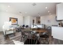 Open-concept living area features a dining area with a round table, seamlessly flowing into a cozy living space at 18079 W Sand Hills Dr, Surprise, AZ 85387