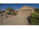 This charming single-story home features a two-car garage and driveway with desert landscaping at 19746 N Wind Rose Way, Surprise, AZ 85374