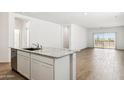 Open-concept kitchen area with tile floors leads to a light-filled living area at 25436 W Graham Trl, Buckeye, AZ 85326