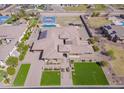 Expansive aerial view of the property, highlighting its pool, tennis court and lush landscaping at 2830 E Fruitvale Ave, Gilbert, AZ 85297