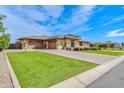 Spacious home showcasing a three-car garage, manicured lawn, and beautiful desert landscaping at 2830 E Fruitvale Ave, Gilbert, AZ 85297