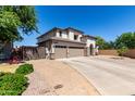 Two story home showcasing a three-car garage, neutral colors and desert landscaping at 34990 N Spur Cir, San Tan Valley, AZ 85144