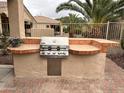 Well-equipped outdoor grill station with tile countertops, ideal for backyard barbecues and entertaining guests at 4203 E Narrowleaf Dr, Gilbert, AZ 85298