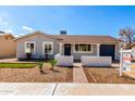 Charming single-story home with well-maintained landscaping, fresh paint, and a covered entryway at 4449 W Turquoise Ave, Glendale, AZ 85302