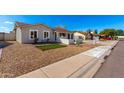 A cozy home featuring manicured gravel landscaping with pops of green and a well-lit facade at 4449 W Turquoise Ave, Glendale, AZ 85302