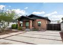 Wide driveway featuring modern concrete block design leading to brick home with black trim and landscaping at 1009 E Garfield St, Phoenix, AZ 85006