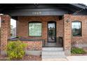 Close-up of brick home's porch showcasing arched windows, stylish tiling, and the house number at 1009 E Garfield St, Phoenix, AZ 85006