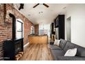 Open-concept design with a cozy fireplace, exposed brick wall, and seamless flow to the kitchen at 1009 E Garfield St, Phoenix, AZ 85006