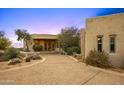 Desert home boasts a circular driveway with lush landscaping, leading to a grand entrance, creating a welcoming appeal at 10325 E Celestial Dr, Scottsdale, AZ 85262