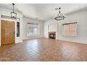 Inviting living room featuring a cozy fireplace and an elegant chandelier at 10816 W Palm Ln, Avondale, AZ 85392