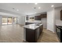 Spacious open kitchen featuring dark cabinets, stainless appliances, and a large center island at 13512 W Copperleaf Ln, Peoria, AZ 85383