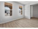 Bright, empty room with wood-look floors and large windows offering great natural light at 13512 W Copperleaf Ln, Peoria, AZ 85383