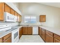 Spacious kitchen featuring white appliances and wood cabinets for ample storage at 13536 W Peck Dr, Litchfield Park, AZ 85340