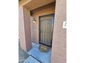 Home's entry featuring a screen door, wall mounted lamp, and a cute 'Home Sweet Home' doormat at 15581 W Caribbean Ln, Surprise, AZ 85379