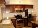 Well-lit kitchen featuring granite countertops, stainless steel appliances, and wood cabinetry at 1920 E Bell Rd # 1073, Phoenix, AZ 85022