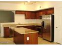 Well-lit kitchen featuring granite countertops, stainless steel appliances, a kitchen island, and wood cabinetry at 1920 E Bell Rd # 1073, Phoenix, AZ 85022