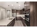 Modern kitchen featuring stainless steel appliances, large island, dark cabinets, and tile flooring at 3551 E Louise Dr, Phoenix, AZ 85050