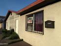 Close up exterior view of building with stucco siding and bars over windows at 4825 N 35Th Ave, Phoenix, AZ 85017