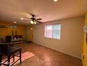 Living room with tile floor and bright yellow accent wall, complete with a fan and window at 4825 N 35Th Ave, Phoenix, AZ 85017