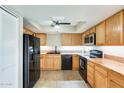 Well-lit kitchen featuring modern black appliances and ample wood cabinetry for storage and meal prep at 1051 S Dobson Rd # 117, Mesa, AZ 85202