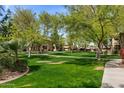 Lush green space with mature trees, lawn, and walking path in a well-maintained community at 1351 N Pleasant Dr # 1087, Chandler, AZ 85225