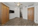 Living room area with wood floors, ceiling fan, and storage cabinets at 14950 W Mountain View Blvd # 3105, Surprise, AZ 85374