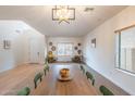 Dining room showcasing modern light fixture, wall decor, with wood table and green chairs at 16011 W Clinton St, Surprise, AZ 85379