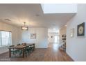 Open dining room with light walls, modern light fixture, and wood and carpet flooring at 16011 W Clinton St, Surprise, AZ 85379