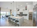 Modern kitchen features island with seating, stainless steel appliances, and adjacent dining area at 1920 E Creek Canyon Rd, Phoenix, AZ 85086